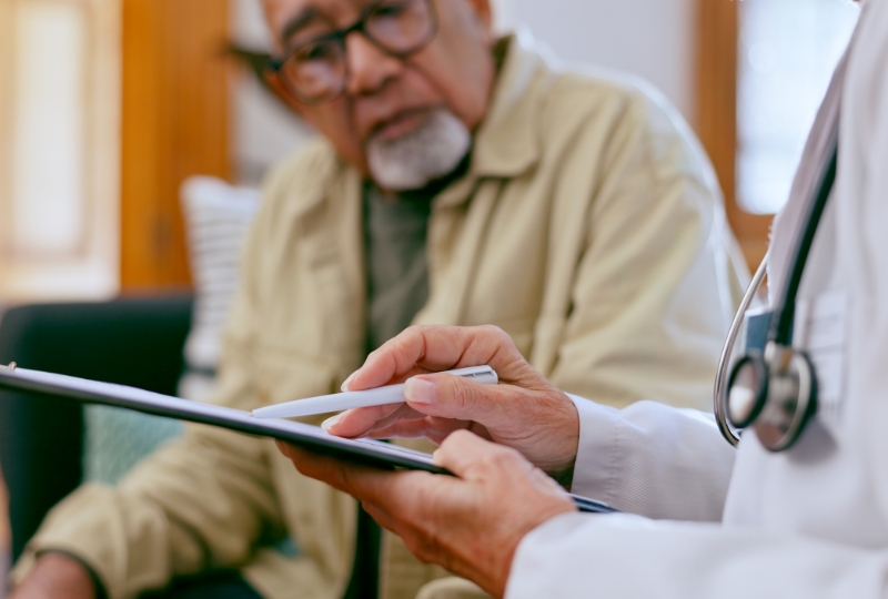 Doctor reviewing medical information with an elderly patient during a consultation